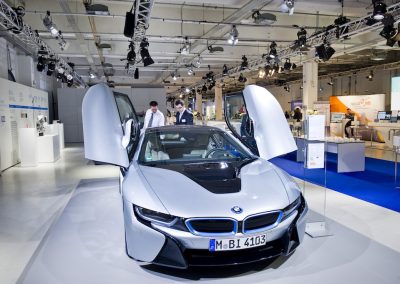 Silberner BMW wird präsentiert, 2 Männer schauen sich das Auto an